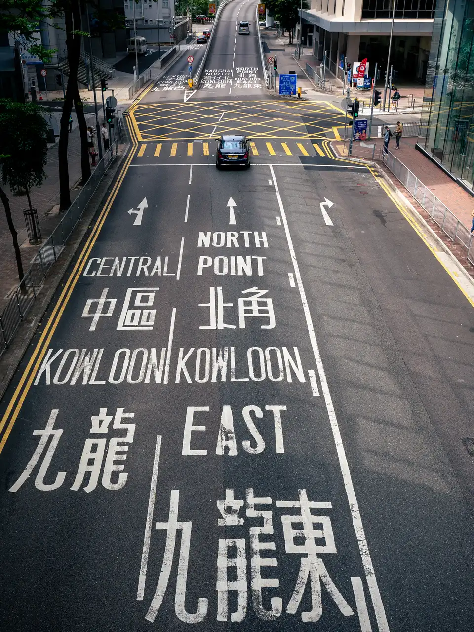 Overhead view of a Kowloon road in Hong Kong with Chinese and English lane markings.