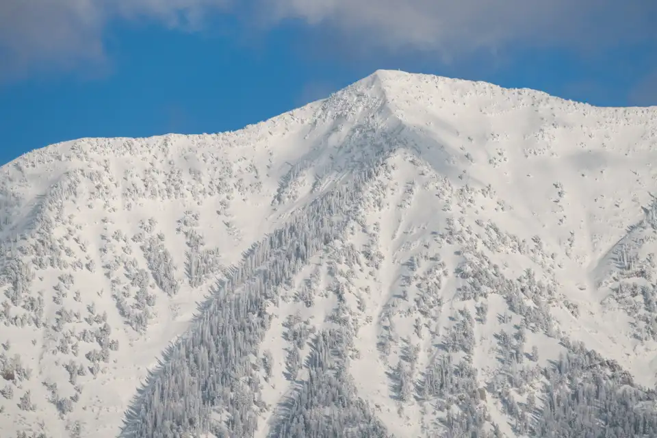 Snow-covered mountain peak with exposed rock and white snow across the frame.